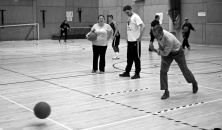 Three people practising bowling a goalball
